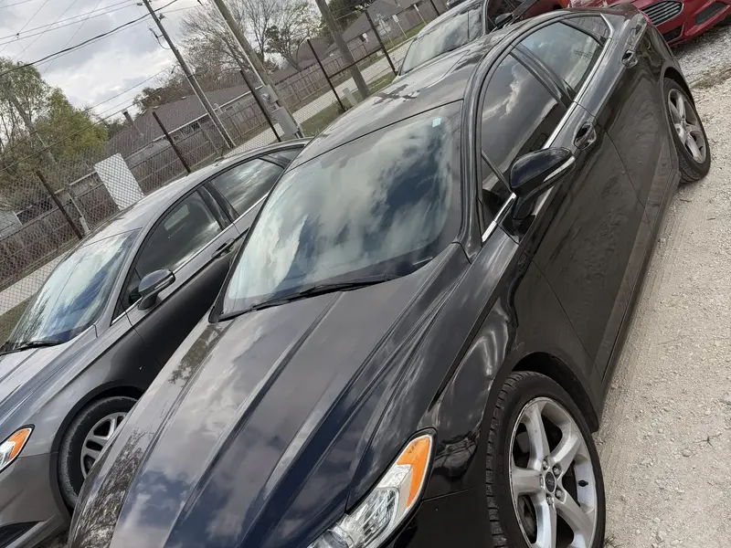 Two black sedans from the SPG Fleet Company rental fleet parked side by side on a lot