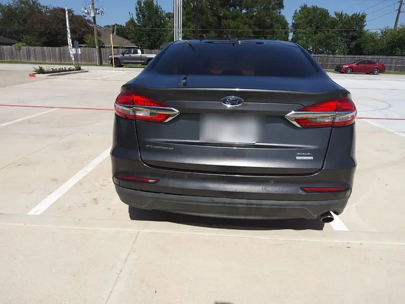 Gray sedan from the SPG Fleet Company fleet parked in a marked space at a Katy pickup location