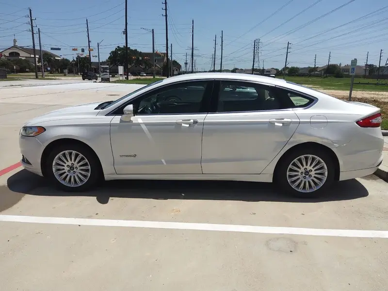 White sedan from the SPG Fleet Company rental fleet parked at a pickup location in Katy, Texas
